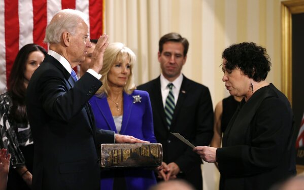 FILE - In this Sunday, Jan. 20, 2013 file photo, Vice President Joe Biden, left, takes the oath of office from Supreme Court Justice Sonia Sotomayor, right, as his wife, Jill Biden, holds the family Bible accompanied by other family members at the U.S. Naval Observatory in Washington. Biden’s use of his family Bible underscores the prominent role that his faith has played in his personal and professional lives. (AP Photos/Kevin Lamarque, Pool)