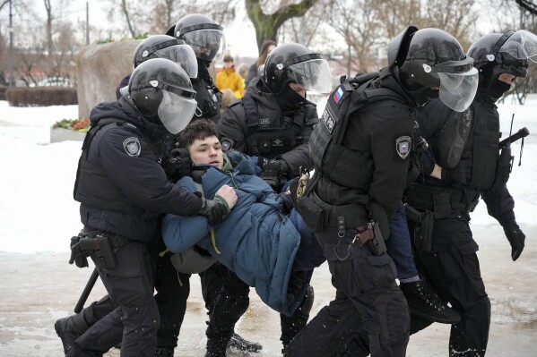 FILE - Police detain a man who wanted to lay flowers to honor Russian opposition leader Alexei Navalny in St. Petersburg, Russia on Saturday, Feb. 17, 2024. Kremlin critics say Russian security agencies are too busy with cracking down on political opponents to pay attention to threats of terrorism in the country. (AP Photo, File)