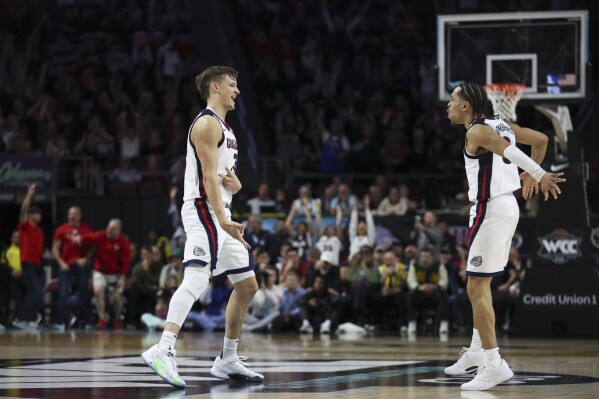 Gonzaga forward Ben Gregg, left, and guard Ryan Nembhard celebrate after Gregg scored a 3-point basket during the second half of an NCAA college basketball game against San Francisco in the semifinals of the West Coast Conference men's tournament Monday, March 11, 2024, in Las Vegas. (AP Photo/Ellen Schmidt)