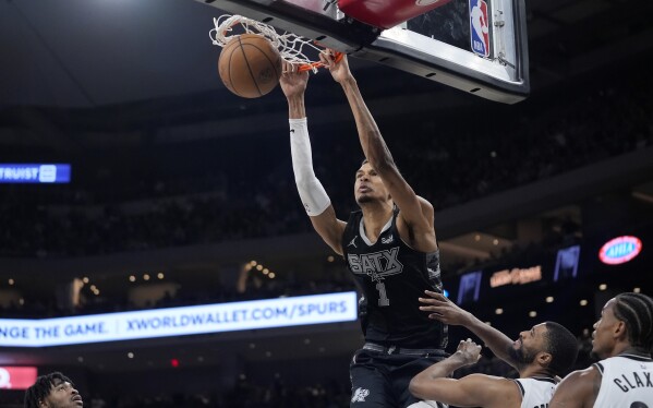San Antonio Spurs center Victor Wembanyama (1) scores against the Brooklyn Nets during the second half of an NBA basketball game in Austin, Texas, Sunday, March 17, 2024. (AP Photo/Eric Gay)