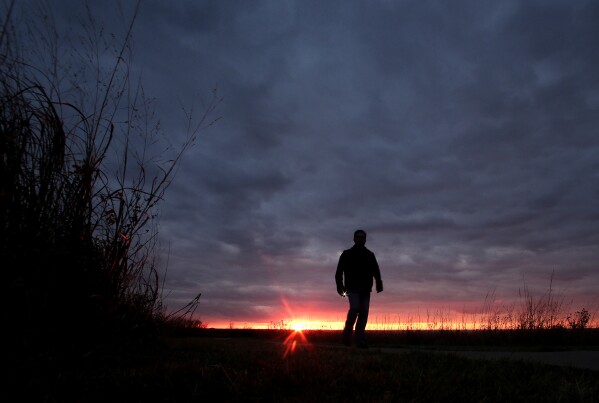 FILE - In this Nov. 20, 2015 file photo, a man walks along a trail during sunset near Manhattan, Kan. In 2022, about 49,500 people took their own lives in the U.S., the highest number ever, according to data from the Centers for Disease Control and Prevention released on Thursday, Aug. 10, 2023. (AP Photo/Charlie Riedel, File)