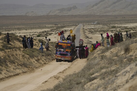 Hindu devotees get off from a bus and walk toward a mud volcano, to start Hindu pilgrims religious rituals for an annual festival in an ancient cave temple of Hinglaj Mata in Hinglaj in Lasbela district in the Pakistan's southwestern Baluchistan province, Friday, April 26, 2024. More than 100,000 Hindus are expected to climb mud volcanoes and steep rocks in southwestern Pakistan as part of a three-day pilgrimage to one of the faith's holiest sites. (AP Photo/Junaid Ahmed)
