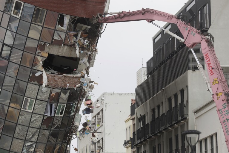 Heavy equipment begins demolition of a collapsed building, two days after a powerful earthquake struck the city, in Hualien City, eastern Taiwan, Friday, April 5, 2024. (AP Photo/Chiang Ying-ying)