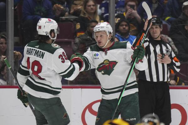 Minnesota Wild's Kirill Kaprizov (97) celebrates his second goal against the Vancouver Canucks with Ryan Hartman (38), during the second period of an NHL hockey game Thursday, March 2, 2023, in Vancouver, British Columbia. (Darryl Dyck/The Canadian Press via AP)