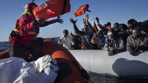 FILE - Migrants and refugees from Africa sailing adrift on an overcrowded rubber boat, receive life jackets from aid workers of the Spanish NGO Aita Mary in the Mediterranean Sea, about 103 miles (165 km) from Libya coast, on Jan. 28, 2022. Last year was the deadliest for migrants in the Middle East and North Africa since 2017, the United Nations said Tuesday, June 13, 2023. About 3,800 people died on migrants’ routes within and from the region, according to data released by the International Organization for Migration’s Missing Migrants Project. (AP Photo/Pau de la Calle, File)