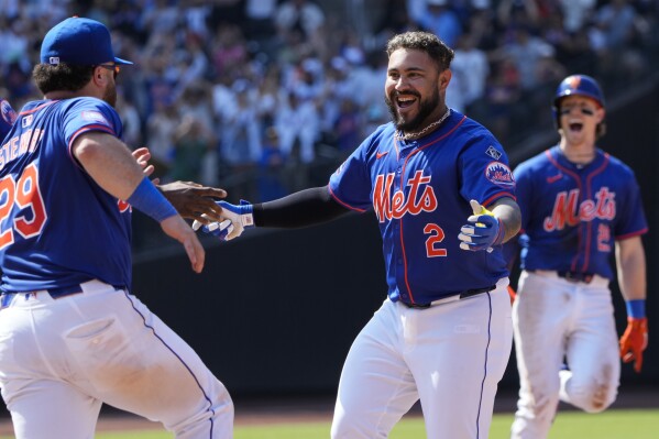 New York Mets' Omar Narváez, center, celebrates with teammates after hitting a walkoff single during the ninth inning of a baseball game against the San Francisco Giants at Citi Field, Sunday, May 26, 2024, in New York. (AP Photo/Seth Wenig)