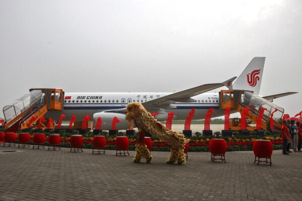 Dancers perform a lion dance near the 100th A320 airplane assembled at the Tianjin plant of Airbus in north China's Tianjin Municipality on Aug. 31, 2012. Multiple passengers were injured after an engine fire sent smoke into the cabin of Air China's Airbus A320 jetliner, the same model seen in this photo, that was landing in Singapore, prompting an evacuation of the aircraft Sunday, Sept. 10, 2023. Changi Airport said in a statement on its Facebook page. The flight was coming from the city of Chengdu in China's Sichuan province. (Chinatopix Via AP)