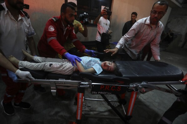 A young Palestinian wounded in the Israeli bombardment of the Gaza Strip is brought to the Kuwaiti Hospital in Rafah refugee camp, southern Gaza Strip, early Saturday, April 20, 2024. (AP Photo/Ismael Abu Dayyah)