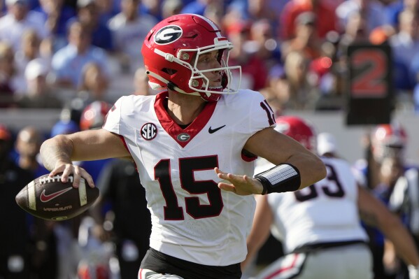 Georgia quarterback Carson Beck (15) looks for a receiver during the first half of an NCAA college football game against Florida, Saturday, Oct. 28, 2023, in Jacksonville, Fla. (AP Photo/John Raoux)