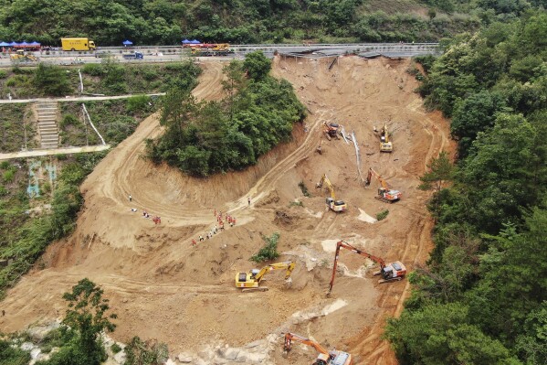 In this photo released by Xinhua News Agency, an aerial drone photo taken on May 2, 2024 shows rescuers and excavators working at the site of a highway section that collapsed on the Meizhou-Dabu Expressway in Meizhou, south China's Guangdong Province. The death toll has climbed as search efforts continue in southern China after a highway section collapsed in a mountainous area, sending more a dozen cars down a steep slope. (Wang Ruiping/Xinhua via AP)