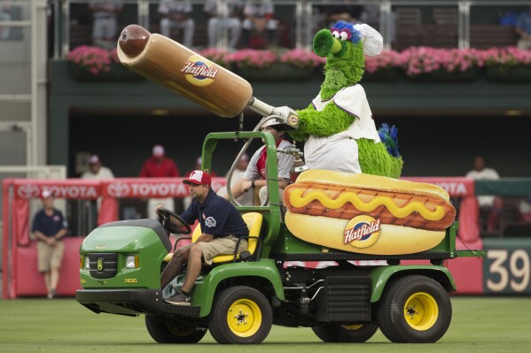 FILE - The Phillie Phanatic comes out with his Hot Dog Launcher during the fifth inning of a baseball game between the Atlanta Braves and the Philadelphia Phillies, Monday, July 4, 2016, in Philadelphia. For more than a quarter-century, Phillies fans thought dollar hot dog night was the best ballpark promotion — but the team has now decided it was the wurst. (AP Photo/Chris Szagola, File)