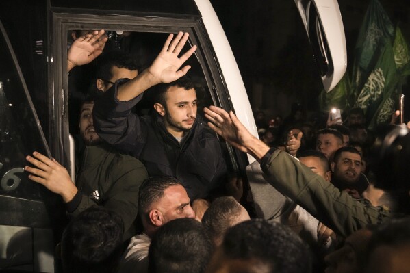 FILE - Men wave after being released from prison by Israel, Thursday, Nov. 30, 2023, in the West Bank town of Ramallah. (APPhoto/Nasser Nasser, File)