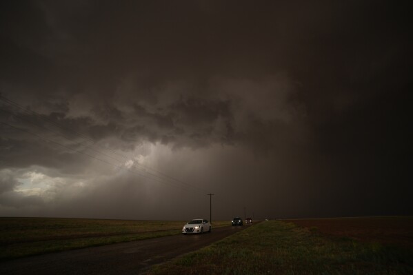 Cars dive away from a storm during a Project ICECHIP operation Thursday, June 5, 2025, in Morton, Texas. (AP Photo/Carolyn Kaster)