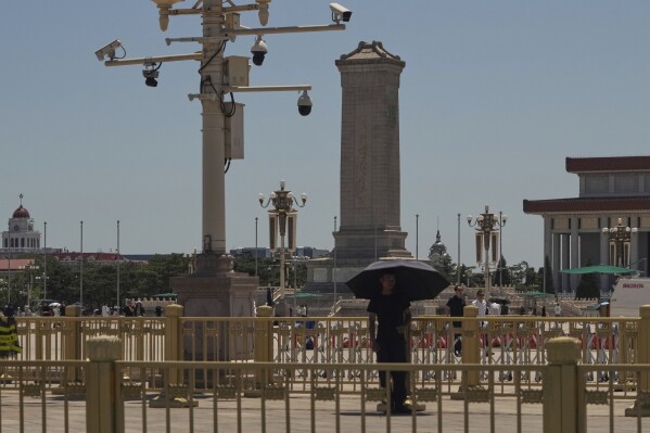 A plain clothes security person stands on duty near security cameras overlooking Tiananmen Square on the anniversary of China's bloody 1989 crackdown on pro-democracy protests in Beijing, Wednesday, June 4, 2025. (AP Photo/Ng Han Guan)