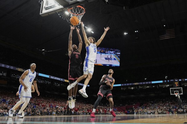 Duke's Tyrese Proctor (5) loses the ball as Houston's Joseph Tugler (11) defends during the second half in the national semifinals at the Final Four of the NCAA college basketball tournament, Saturday, April 5, 2025, in San Antonio. (AP Photo/Eric Gay)