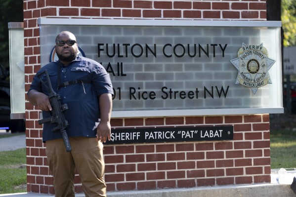 An official stands guard in front of the Fulton County Jail in Atlanta on Thursday, Aug. 24, 2023. (AP Photo/Ben Gray)