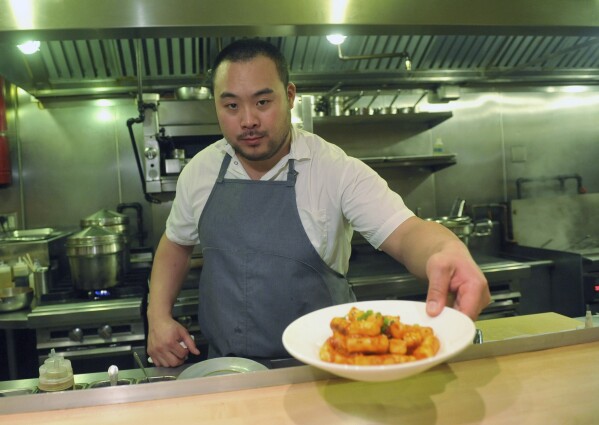 FILE - David Chang presents a dish at Momofuku Noodle Bar in New York on Thursday, Nov. 10, 2011. On Friday, April 12, 2024, Momofuku, a food and restaurant brand started by food mogul Chang, said it won't defend its trademark on the name “chile crunch” after it sparked an outcry by sending cease-and-desist letters to other businesses using the term. (AP Photo/Diane Bondareff, File)