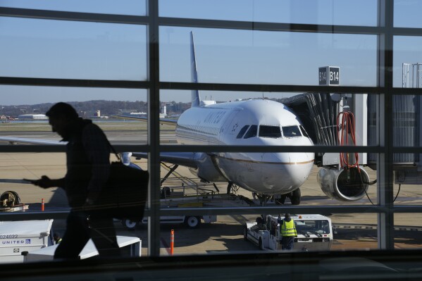 File - A United Airlines plane sits at a gate at Ronald Reagan Washington National Airport in Arlington, Va., Nov. 23, 2022. United Airlines says that it will start boarding passengers in economy class with window seats first starting next week, a move that will speed up boarding times for flights. (AP Photo/Patrick Semansky, File)