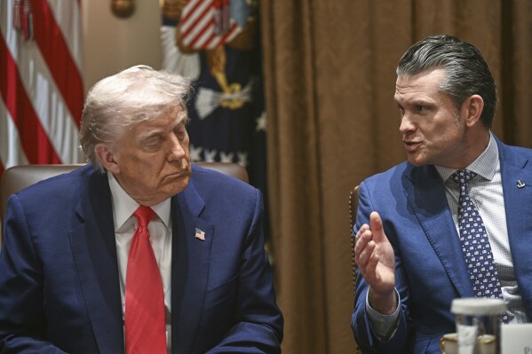 President Donald Trump listens as Defense Secretary Pete Hegseth speaks at a cabinet meeting in the Cabinet Room of the White House, Thursday, April 10, 2025, in Washington (Pool via AP)