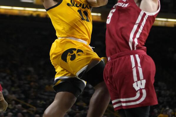 Iowa guard Tony Perkins (11) drives to the basket past Wisconsin forward Tyler Wahl (5) during the second half of an NCAA college basketball game, Sunday, Dec. 11, 2022, in Iowa City, Iowa. (AP Photo/Charlie Neibergall)