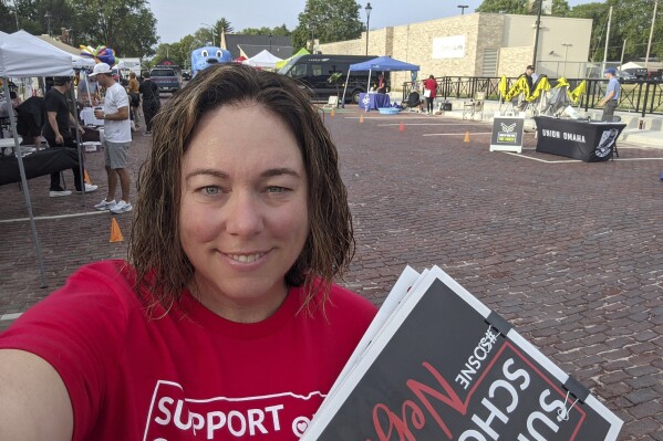 In this June 2023 selfie, Angie Lauritsen collects signatures in downtown Gretna, Neb., for a ballot initiative seeking to repeal a state law that would divert taxpayer money to pay for private school tuition. Nebraska lawmakers are set for the first time to pass a bill that would block the public from voting on a ballot measure initiated by citizens of the state, setting up what could be a long battle over whether to fund private school tuition with public dollars. (Angie Lauritsen via AP)