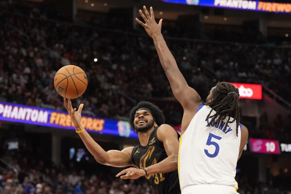 Cleveland Cavaliers center Jarrett Allen (31) shoots in front of Golden State Warriors forward Kevon Looney (5) in the second half of an NBA basketball game, Friday, Nov. 8, 2024, in Cleveland. (AP Photo/Sue Ogrocki)