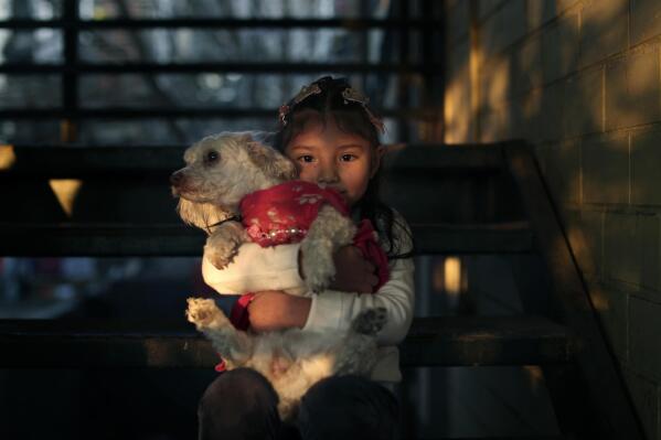 Kehity Collantes, 6, poses for a picture with her dog, Niña, in Santiago, Chile, Sunday, July 4, 2021. Collantes' mother died from the coronavirus. (AP Photo/Esteban Felix)