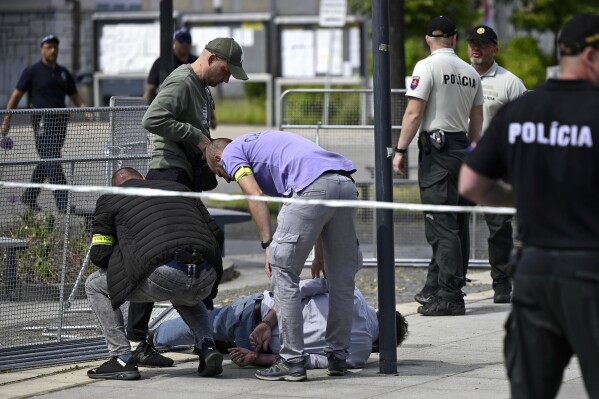 Police arrest a man after Slovak Prime Minister Robert Fico was shot and injured following the cabinet's away-from-home session in the town of Handlova, Slovakia, Wednesday, May 15, 2024. Fico is in life-threatening condition after being wounded in a shooting Wednesday afternoon, according to his Facebook profile. (Radovan Stoklasa/TASR via AP)