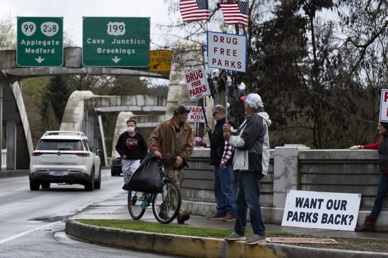 Members of the self-proclaimed "park watch" group protest on Friday, March 22, 2024, in Grants Pass, Ore. (AP Photo/Jenny Kane)