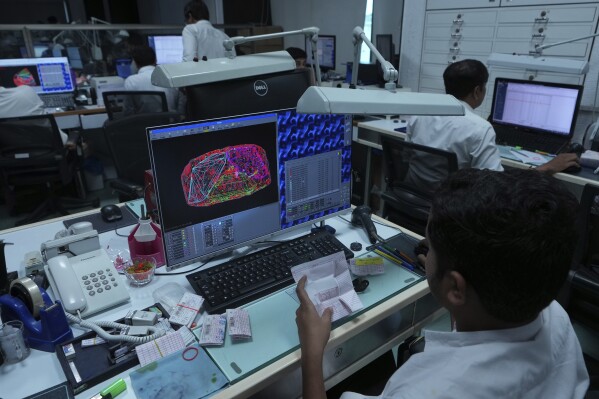 An employee consults a blueprint for cutting a raw diamond at Shree Ramkrishna Exports in Surat, India, on April 14, 2025. (AP Photo/Ajit Solanki)