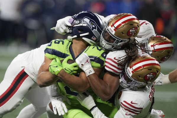 Seattle Seahawks running back Zach Charbonnet (26) is tackled during the first half of an NFL football game against the San Francisco 49ers, Thursday, Nov. 23, 2023, in Seattle. (AP Photo/Stephen Brashear)