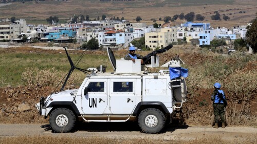 U.N. peacekeepers patrol on the Lebanese side of the Lebanese-Israeli border in the southern village of Wazzani with border village Ghajar in the background, Thursday, July 6, 2023. Israeli forces shelled a southern Lebanese border village on Thursday after several explosions were heard in a disputed area where the borders of Syria, Lebanon and Israel meet. (AP Photo/Mohammad Zaatari)