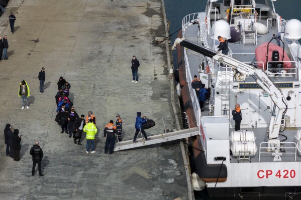 Migrants board an Italian Coast Guard vessel as part of a transfer operation from the asylum processing centers in Albania back to Italy following a court decision in Rome, at the port of Shengjin, northwestern Albania, Saturday, Feb. 1, 2025. (AP Photo/Vlasov Sulaj)