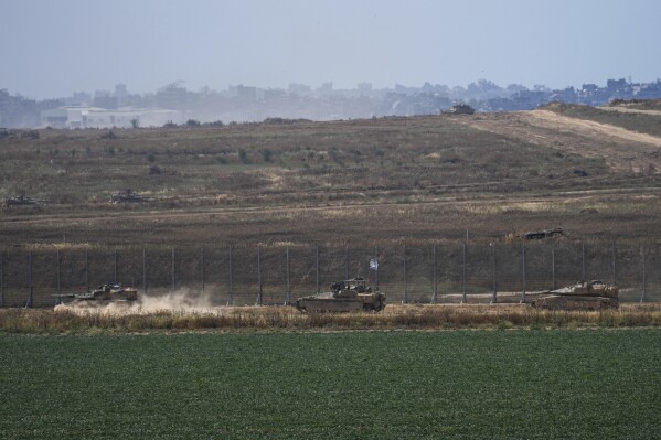 Israeli tanks move near the Israeli-Gaza border, as seen from southern Israel, Sunday, May 12, 2024. (AP Photo/Tsafrir Abayov)