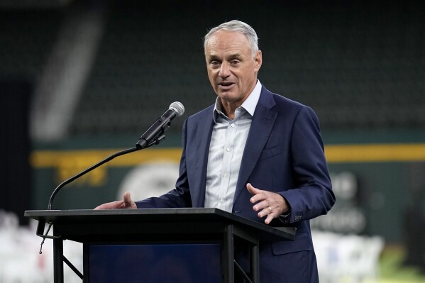 Major League Baseball Commissioner Rob Manfred makes comments before the unveiling of the 2024 All-Star game logo, Thursday, July 20, 2023, in Arlington, Texas. The MLB All-Star Game has grown into a truly Texas-sized event since the last time the Rangers hosted the midsummer classic. The countdown is on for 2024 game on July 16, and all of the activities around the game. (AP Photo/Tony Gutierrez)
