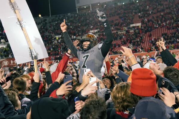 Utah quarterback Cameron Rising (7) celebrates with students who rushed the field following an NCAA college football game against Oregon, Saturday, Nov. 20, 2021, in Salt Lake City. (AP Photo/Rick Bowmer)