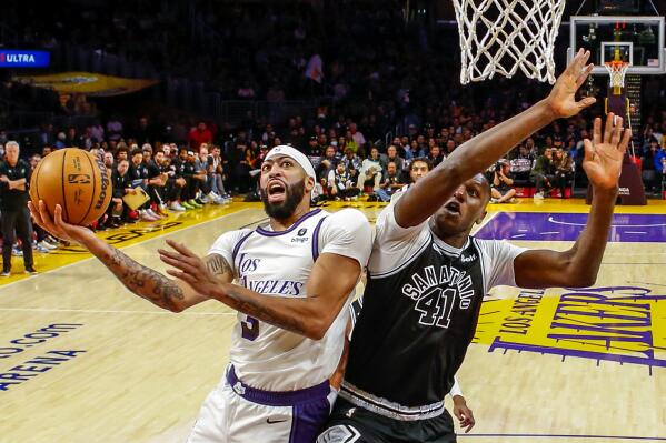 Los Angeles Lakers forward Anthony Davis, left, shoots under pressure from San Antonio Spurs forward Gorgui Dieng during the first half of an NBA basketball game, Sunday, Nov. 20, 2022, in Los Angeles. (AP Photo/Ringo H.W. Chiu)