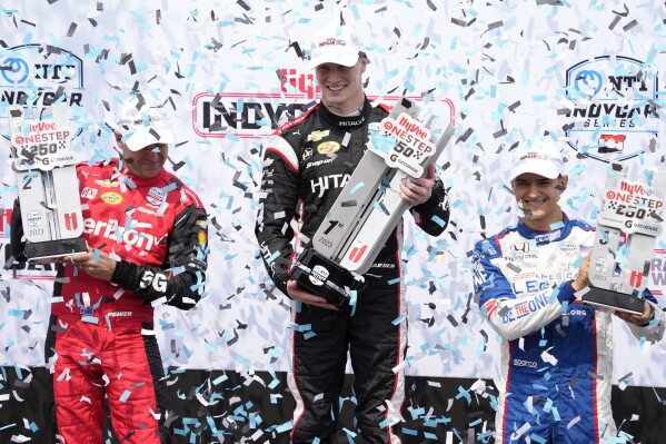 From left, Will Power, of Australia, Josef Newgarden and Alex Palou, of Spain, celebrate on the victory stand after an IndyCar Series auto race, Sunday, July 23, 2023, at Iowa Speedway in Newton, Iowa. (AP Photo/Charlie Neibergall)