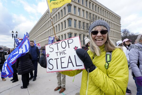 Alyss Kovach holds a sign outside the Richard H. Austin state office building during a rally in Lansing, Mich., Saturday, Nov. 14, 2020. Michigan's elections board is meeting to certify the state's presidential election results. (AP Photo/Paul Sancya)