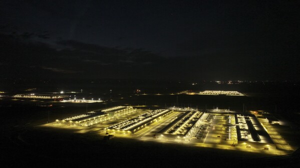 An Amazon Web Services data center lights up the night in Boardman, Ore., on Thursday, Aug. 22, 2024. (AP Photo/Jenny Kane)