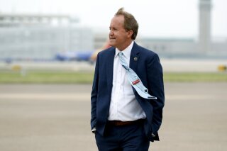 FILE - In this June 28, 2020, file photo, Texas Attorney General Ken Paxton waits on the flight line for the arrival of Vice President Mike Pence at Love Field in Dallas.  Paxton had an extramarital affair with a woman whom he later recommended for a job with the wealthy donor now at the center of criminal allegations against him, according to two people who said Paxton told them about the relationship. (AP Photo/Tony Gutierrez, File)