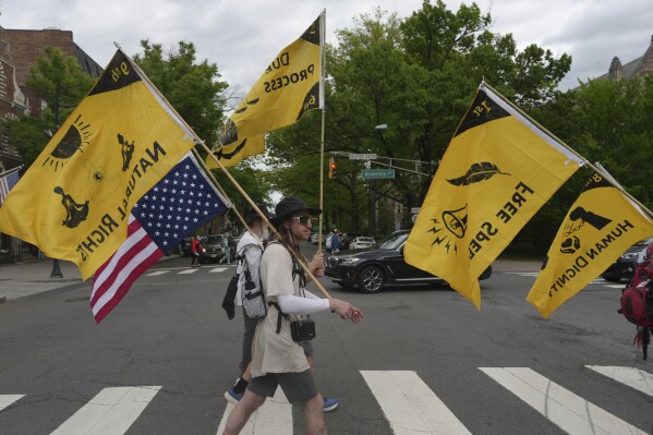 Ross Brubeck and other members of the Quaker March to Washington cross a street on their way to a meeting house in Princeton, N.J., on Wednesday May 7, 2025. (AP Photo/Luis Andres Henao)