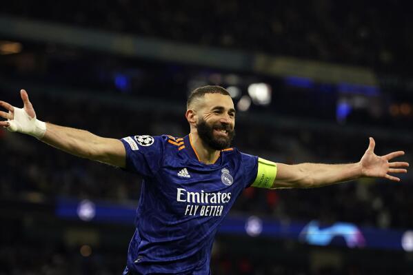 Real Madrid's Karim Benzema celebrates after scoring his side's third goal from penalty during the Champions League semi final, first leg soccer match between Manchester City and Real Madrid at the Etihad stadium in Manchester, England, Tuesday, April 26, 2022. (AP Photo/Dave Thompson)