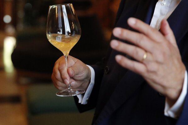 Paul Francois Vranken, Director of Vranken-Pommery Monopole holds a glass during an interview in the Champagne region, east of Paris, Tuesday, July 28, 2020. Producers in France’s eastern Champagne region, headquarters of the global industry, say they’ve lost about 1.7 billion euros ($2 billion) in sales this year, as turnover fell by a third —  a hammering unmatched in living memory, and worse than the Great Depression. (AP Photo/Francois Mori)