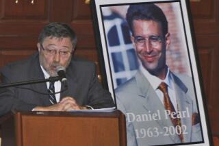 FILE - Dr. Judea Pearl, left, father of American journalist Daniel Pearl, right, who was killed by terrorists in 2002, speaks in Miami Beach, Fla., April 15, 2007. Geivens Dextra, a violinist who is scheduled to graduate from Pittsfield High School next week, is this year's recipient of a college scholarship given in honor of former Wall Street Journal reporter Daniel Pearl, who was kidnapped and killed in Pakistan in January 2002 while investigating a story on terrorism. (AP Photo/Wilfredo Lee, File)