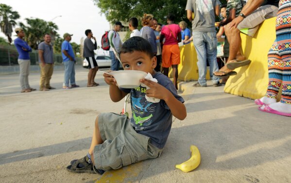 
              William Linares, 5, who is traveling with his mother Suanny Gomez from Honduras and seeking asylum in the United States eats breakfast provided by volunteers, Tuesday, April 30, 2019, in Matamoros, Mexico. Gomez said she does not have money to pay a proposed fee for seeking asylum. (AP Photo/Eric Gay)
            