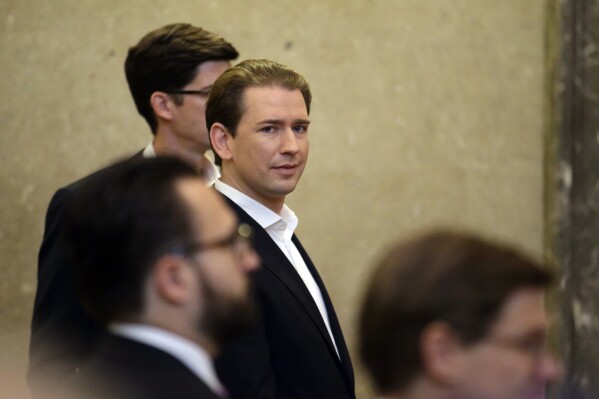 Former Austrian Chancellor Sebastian Kurz, center, appears at court on the first day of his trial in Vienna, Austria, Wednesday, Oct. 18, 2023. Kurz is charged with having allegedly making false statements to a parliamentary inquiry into alleged corruption in his first government. (AP Photo/Heinz-Peter Bader)