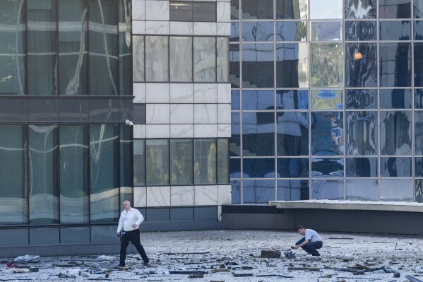 Investigators examine an area next to a damaged building in the "Moscow City" business district after a reported drone attack in Moscow, Russia, early Tuesday, Aug. 1, 2023. Ukrainian drones again targeted Moscow and its surroundings early Tuesday morning, the Russian military reported. Two of three launched were shot down outside Moscow, while one crashed into a skyscraper in the Moscow City business district, damaging the building’s facade. (AP Photo)