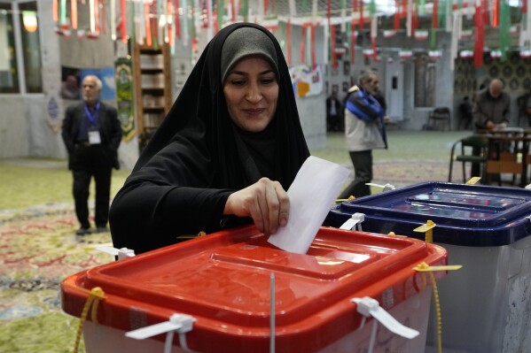 A woman casts her ballot during the parliamentary and Assembly of Experts elections at a polling station in Tehran, Iran, Friday, March 1, 2024. Iran held the country's first election since the mass 2022 protests over mandatory hijab laws after the death in police custody of Mahsa Amini, with questions looming over just how many people will turn out at the polls. (AP Photo/Vahid Salemi)