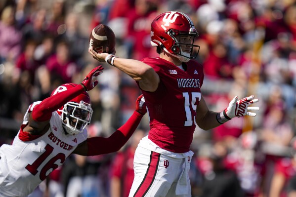 Indiana quarterback Brendan Sorsby (15) is pressured by Rutgers defensive back Max Melton (16) during the first half of an NCAA college football game in Bloomington, Ind., Saturday, Oct. 21, 2023. (AP Photo/Michael Conroy)